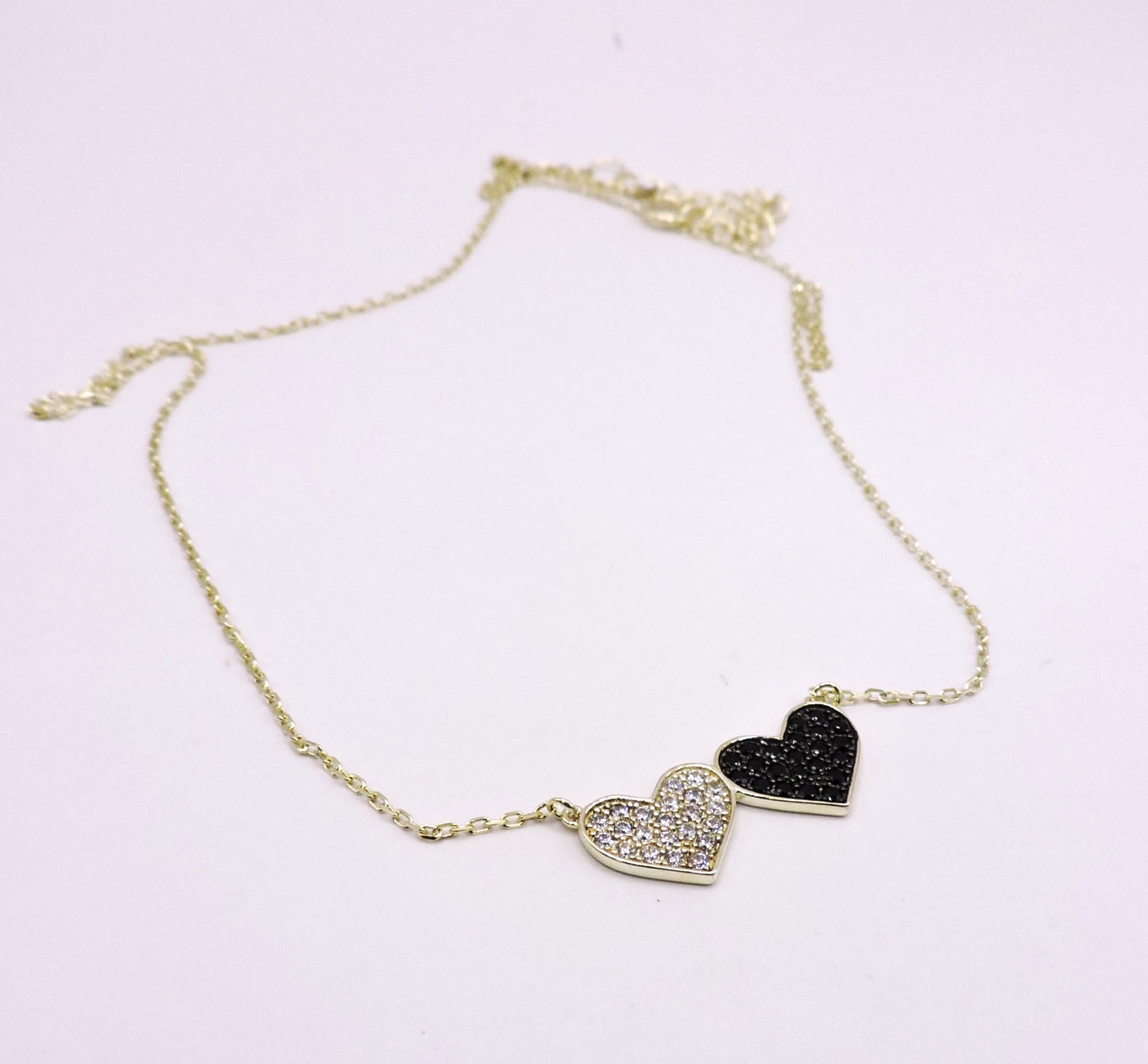 Silver necklace with black and white zircons, in the shape of a double heart