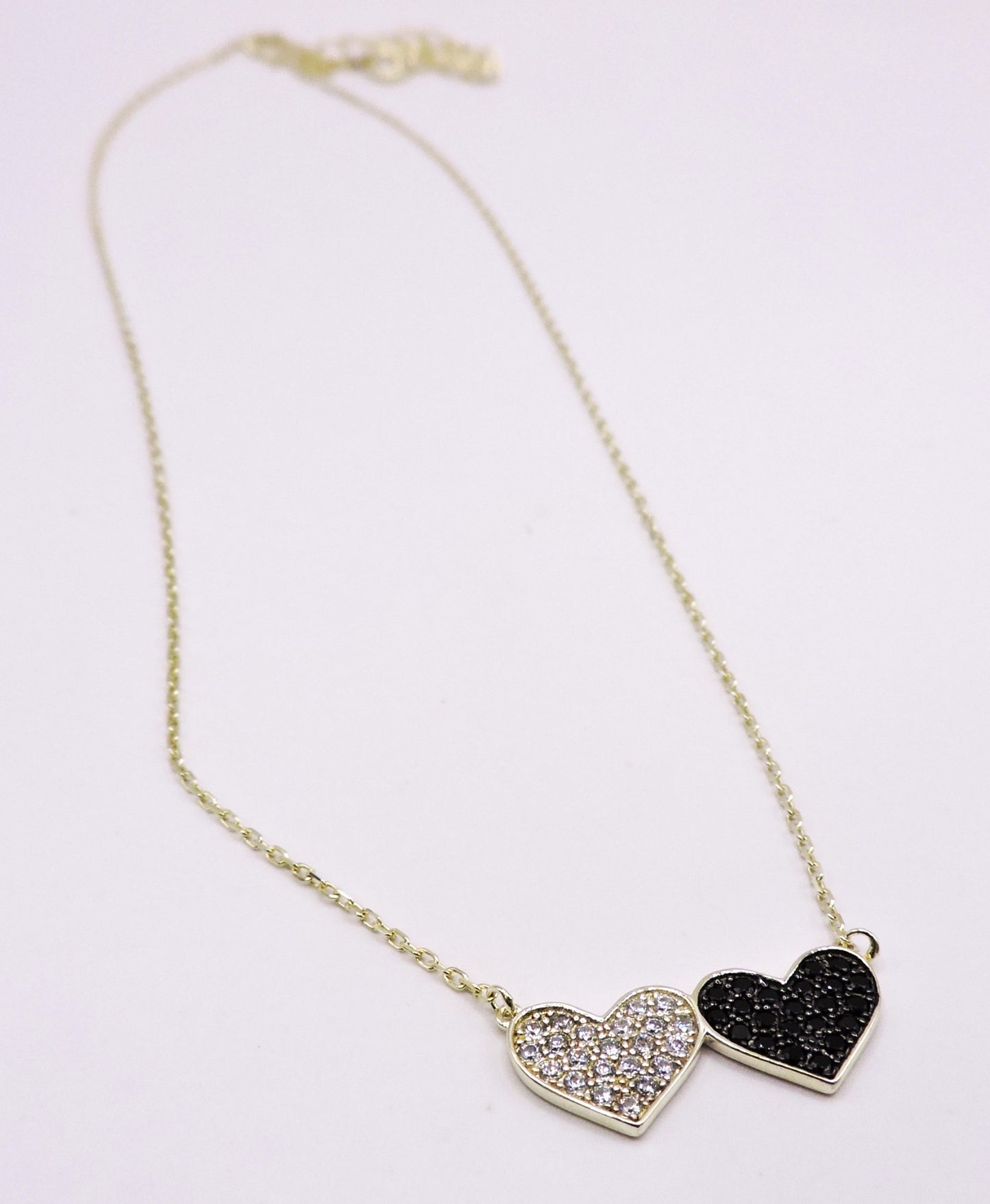 Silver necklace with black and white zircons, in the shape of a double heart