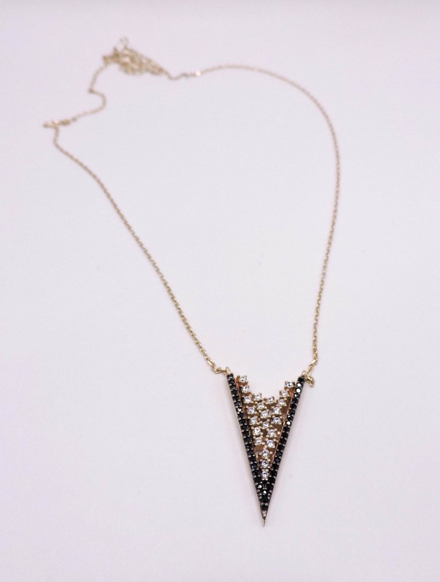 White and black zircon necklace in rose-plated silver in the shape of an arrowhead