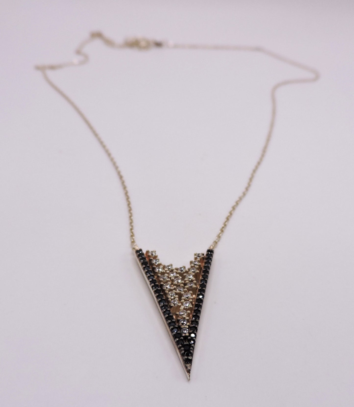 White and black zircon necklace in rose-plated silver in the shape of an arrowhead