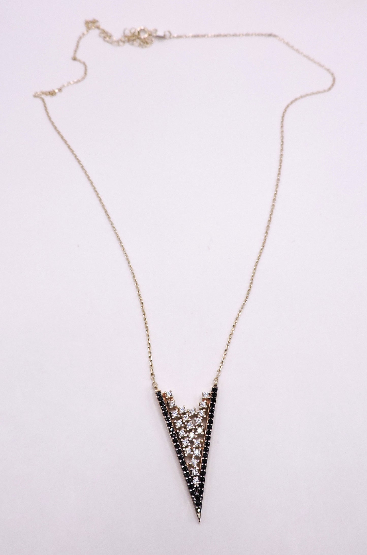 White and black zircon necklace in rose-plated silver in the shape of an arrowhead